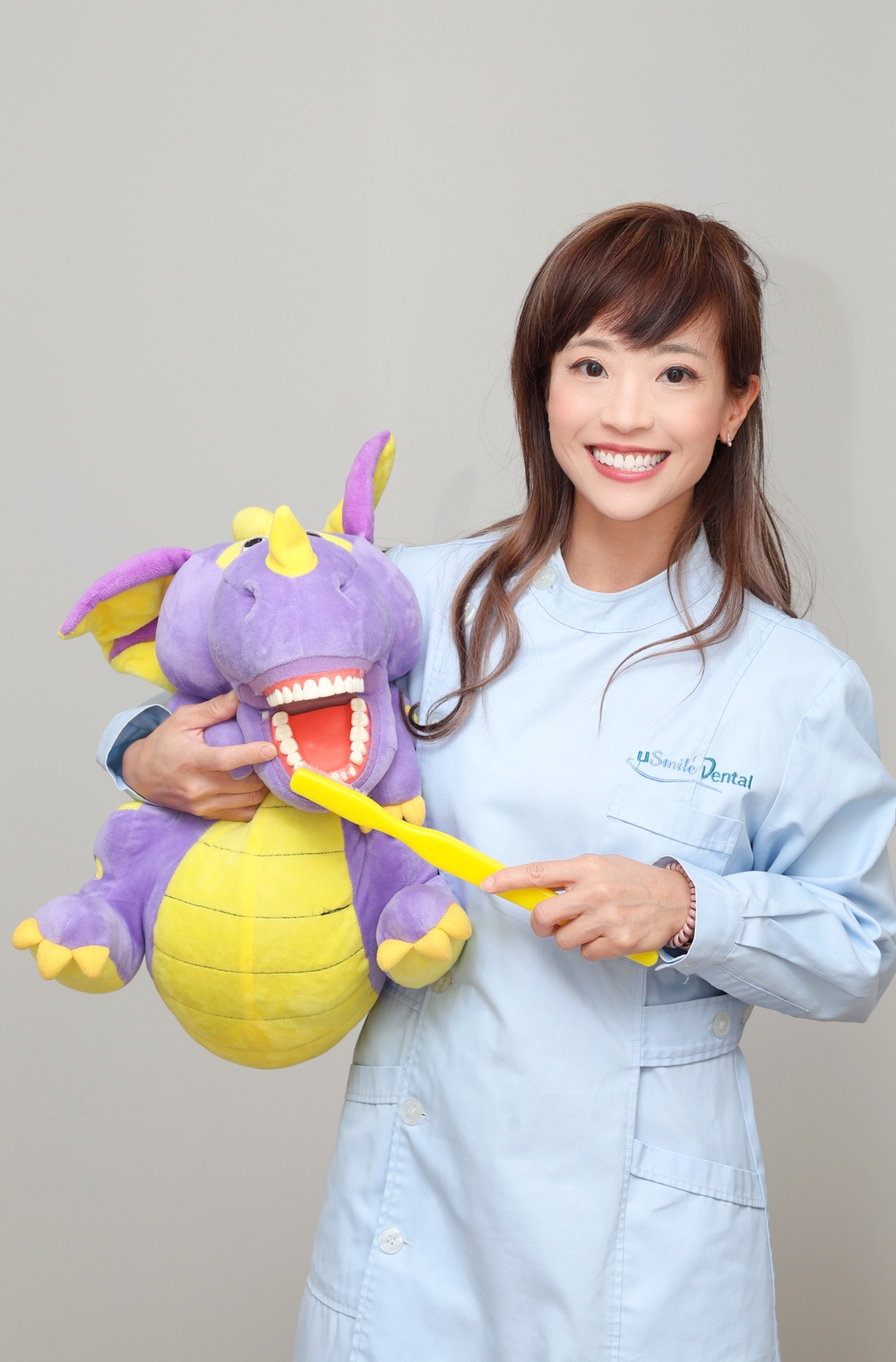 A uSmile Dental clinician introducing toothbrushing with a friendly dental puppet